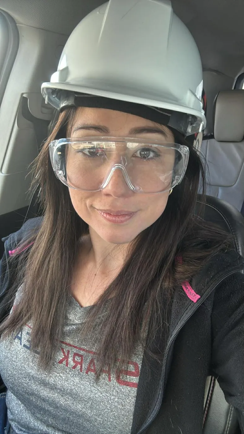 Ana Velasquez wearing job-site hard hat and safety glasses