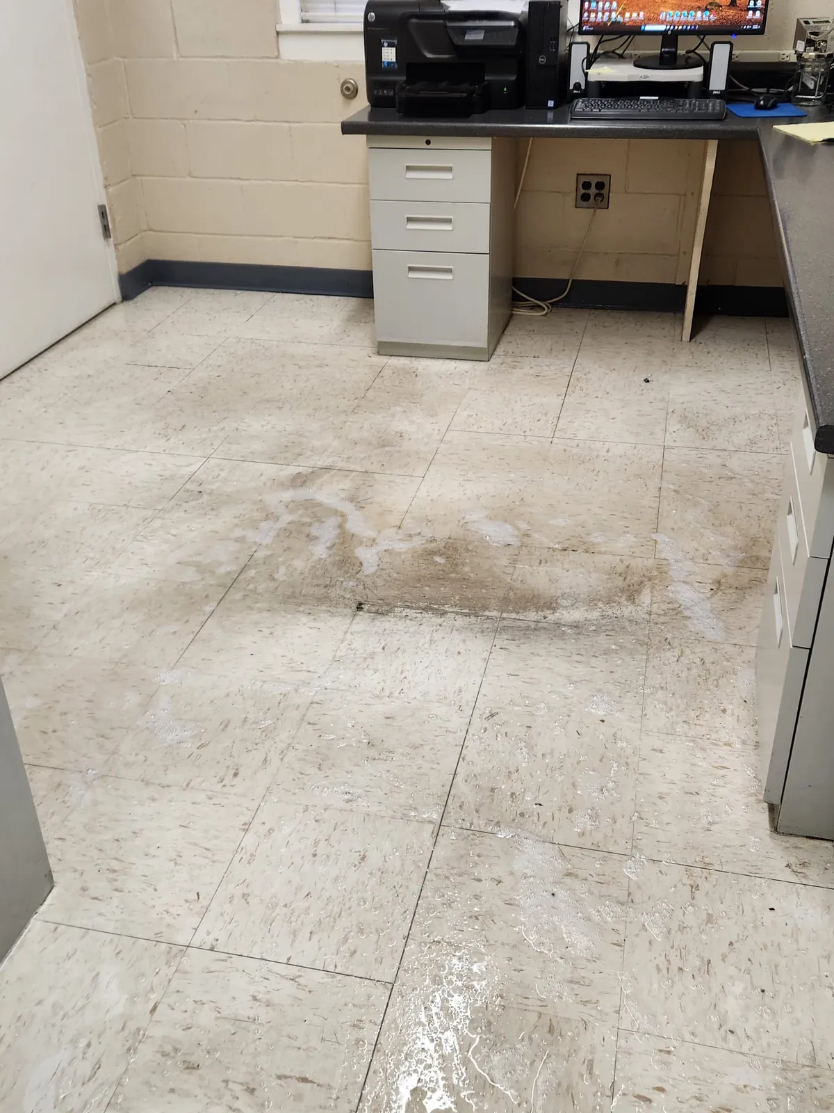 Dirty common-area floor before cleaning, with visible soil and dull finish
